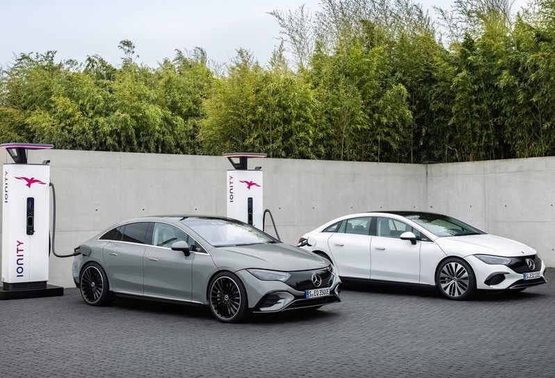 İki Mercedes-Benz EQE sedanın hızlı şarj istasyonları yanında görünümü