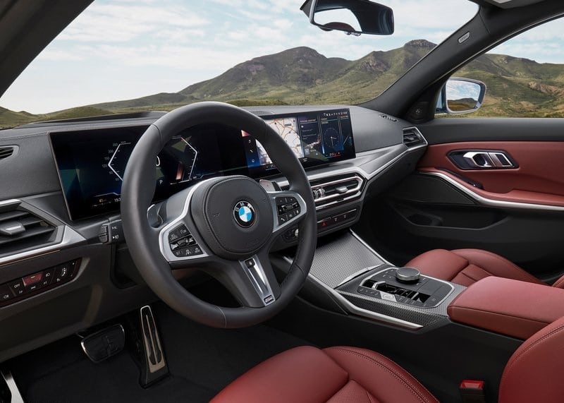 BMW 3 Serisi iç mekanda direksiyon kavisli ekran ve kırmızı koltuklar