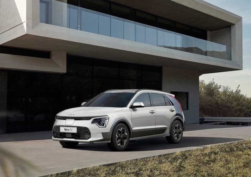 Beyaz Kia Niro EV modern yapı önünde