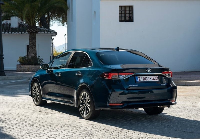Koyu mavi Toyota Corolla Sedan taş döşeli alanda arka üç çeyrek görünüm