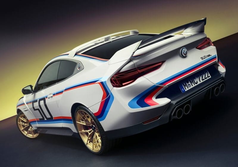 Beyaz BMW coupe arka üç çeyrek görünümde büyük kanat ve dört egzoz çıkışı