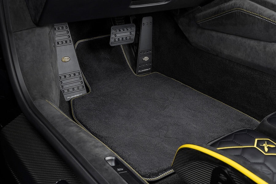 Sürücü ayak bölümündeki metal pedallar ve koyu halı detayı