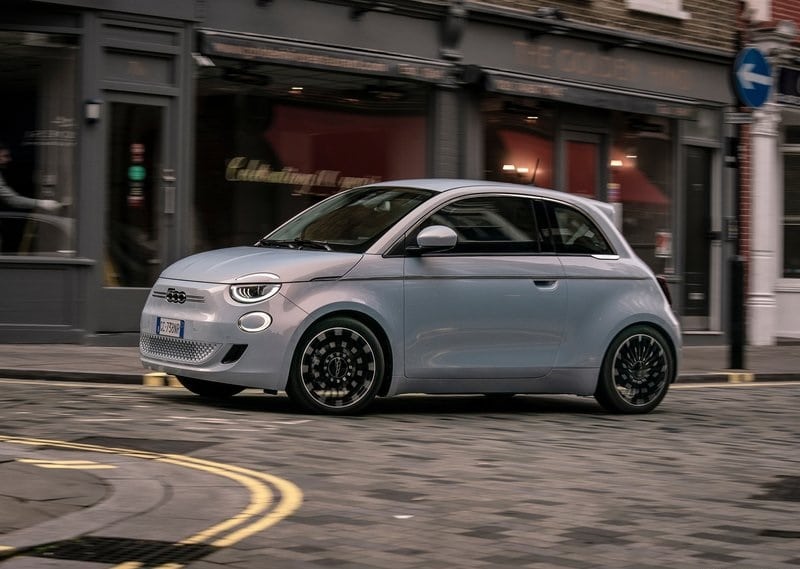 Şehir içinde hareket halindeki açık renk Fiat 500e