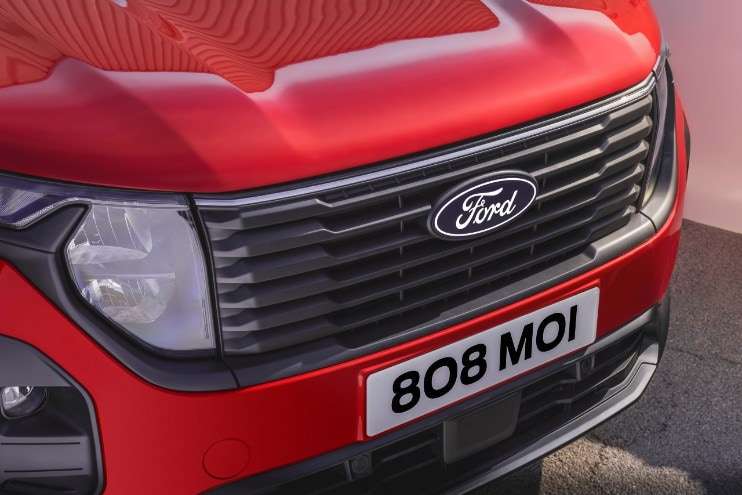 Kırmızı Transit Courier ön ızgarası ve Ford logosu yakın görünüm