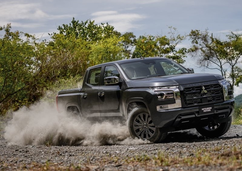 Koyu gri Mitsubishi Triton çift kabin pick up çakıllı zeminde sürüş