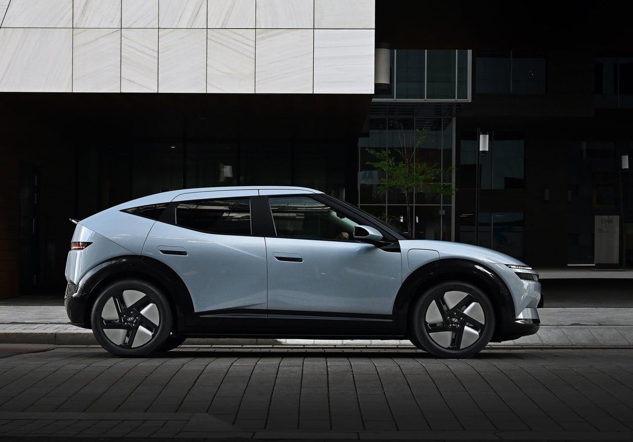 Açık mavi IONIQ 3 şehir ortamındaki yan profil görünümü